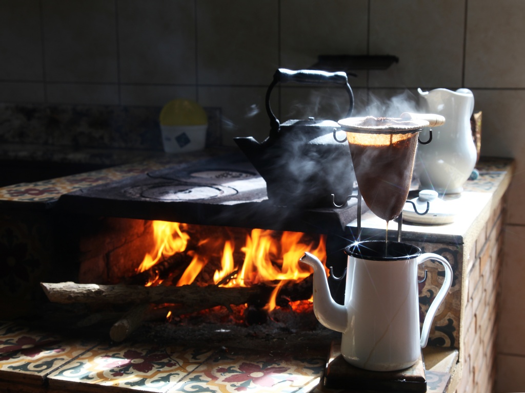 café sendo feito na chaleira, em fogão a lenha, com fumaça ao fundo